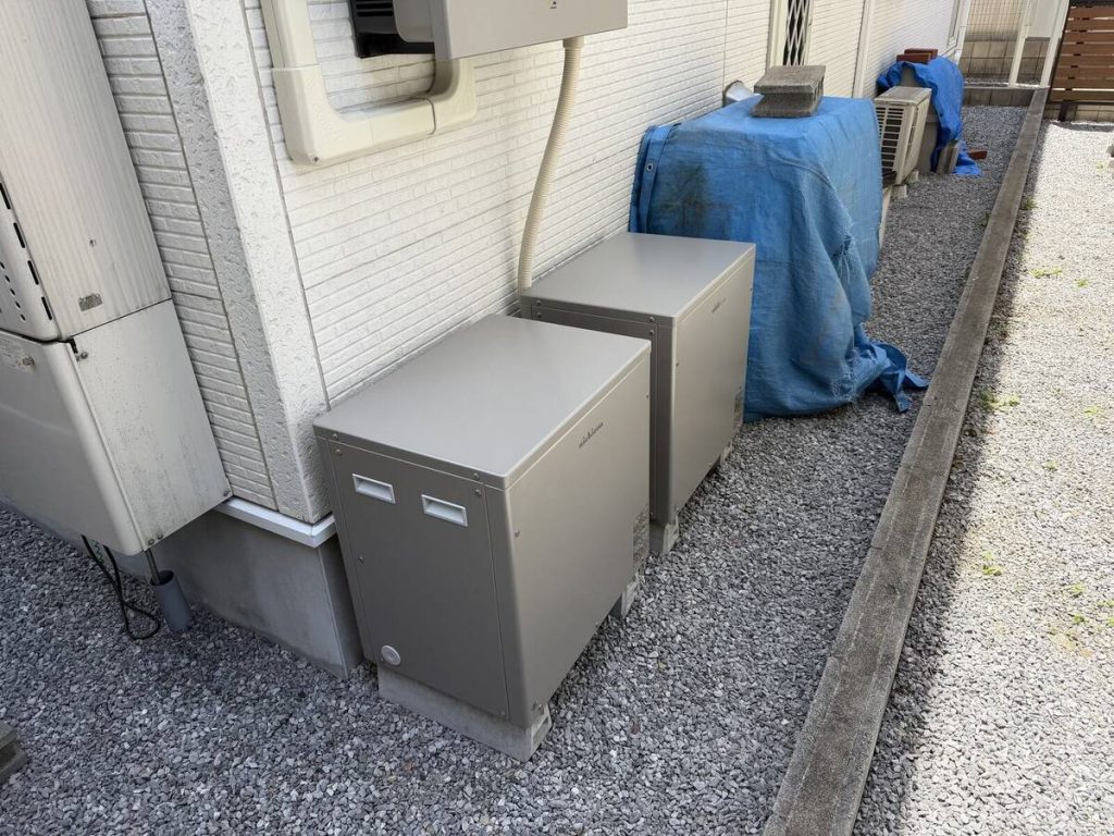 屋根面の太陽光パネルと建物側面の蓄電関連機器