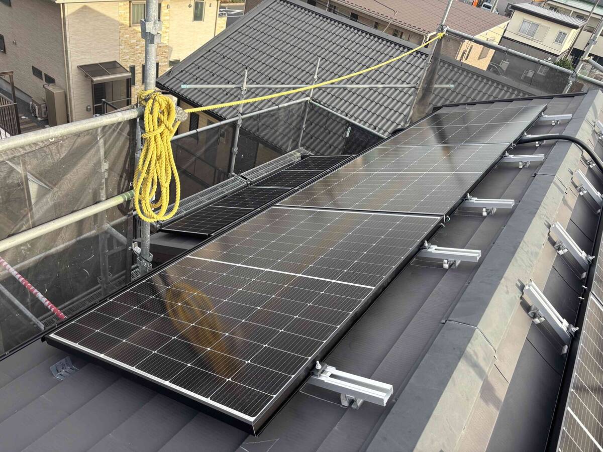 屋根中央の太陽光パネルとフェンス際の蓄電池