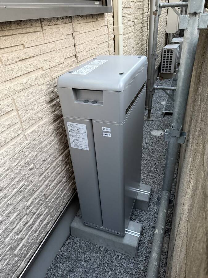 砂利敷き通路の蓄電池と外壁三連機器