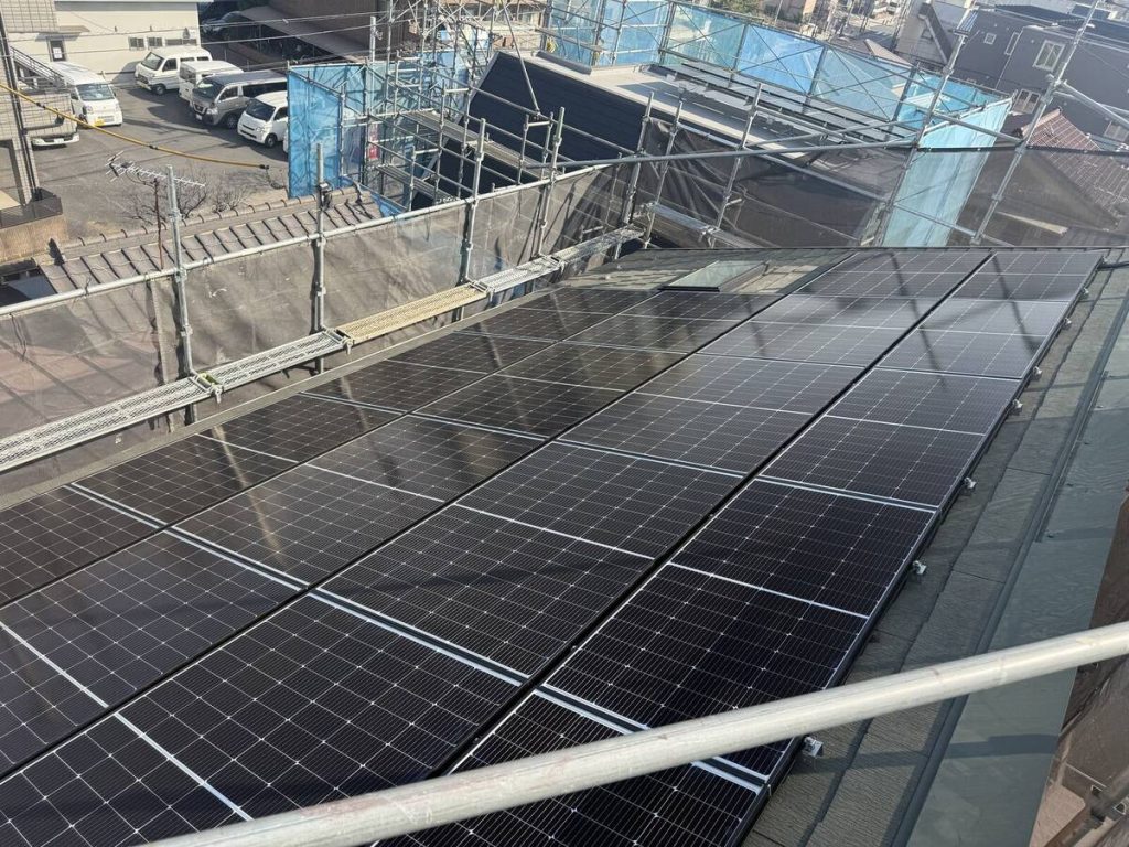 金属屋根の太陽光パネルとレンガ調外壁脇の蓄電池