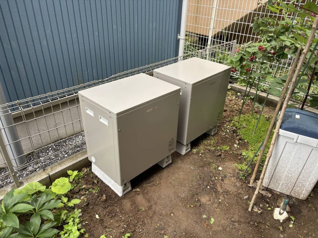 細長い屋根の太陽光パネルと二台構成の蓄電設備