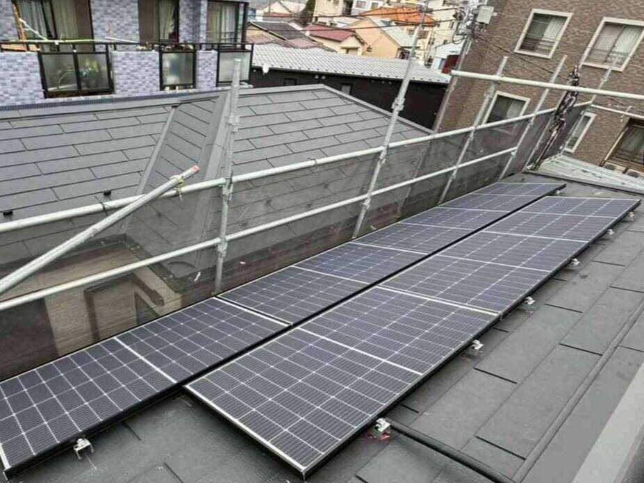 赤色屋根の太陽光パネルと建物間の薄型蓄電池