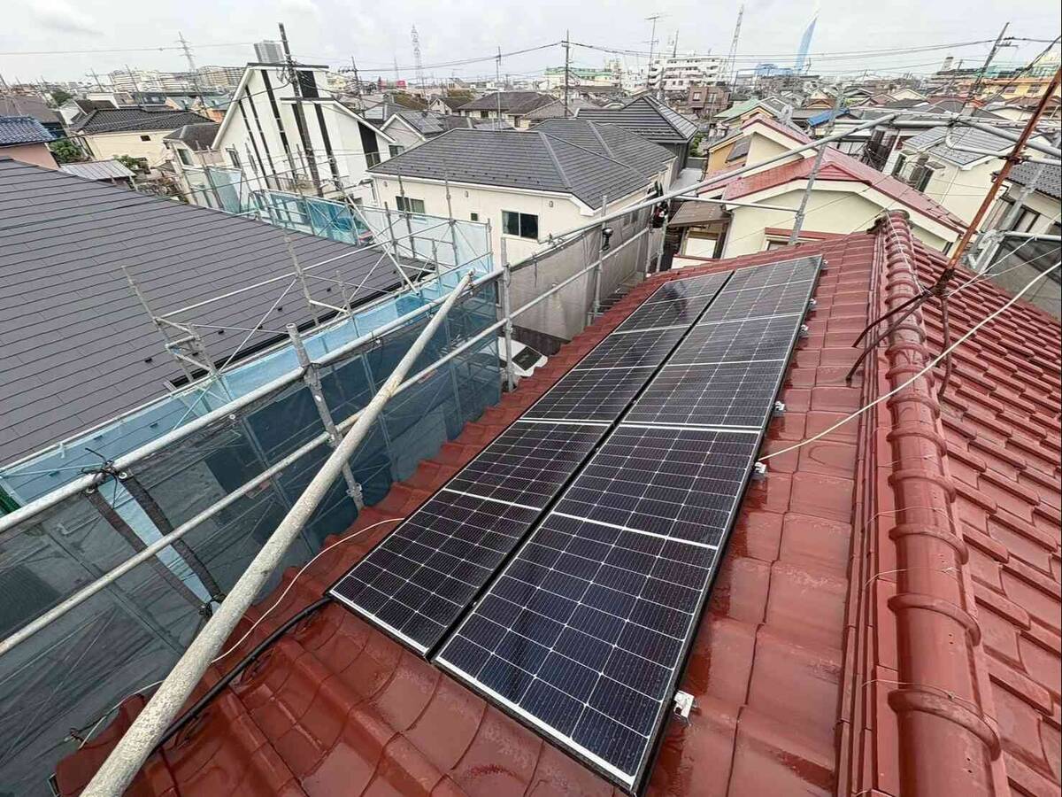 赤い瓦屋根の太陽光パネルとコンパクト蓄電池
