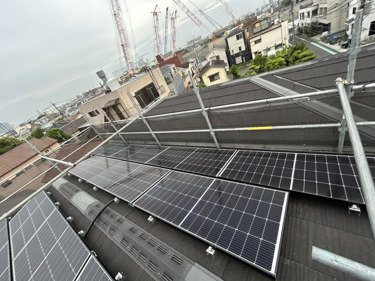 黒い屋根の太陽光パネルと蓄電関連機器の銘板