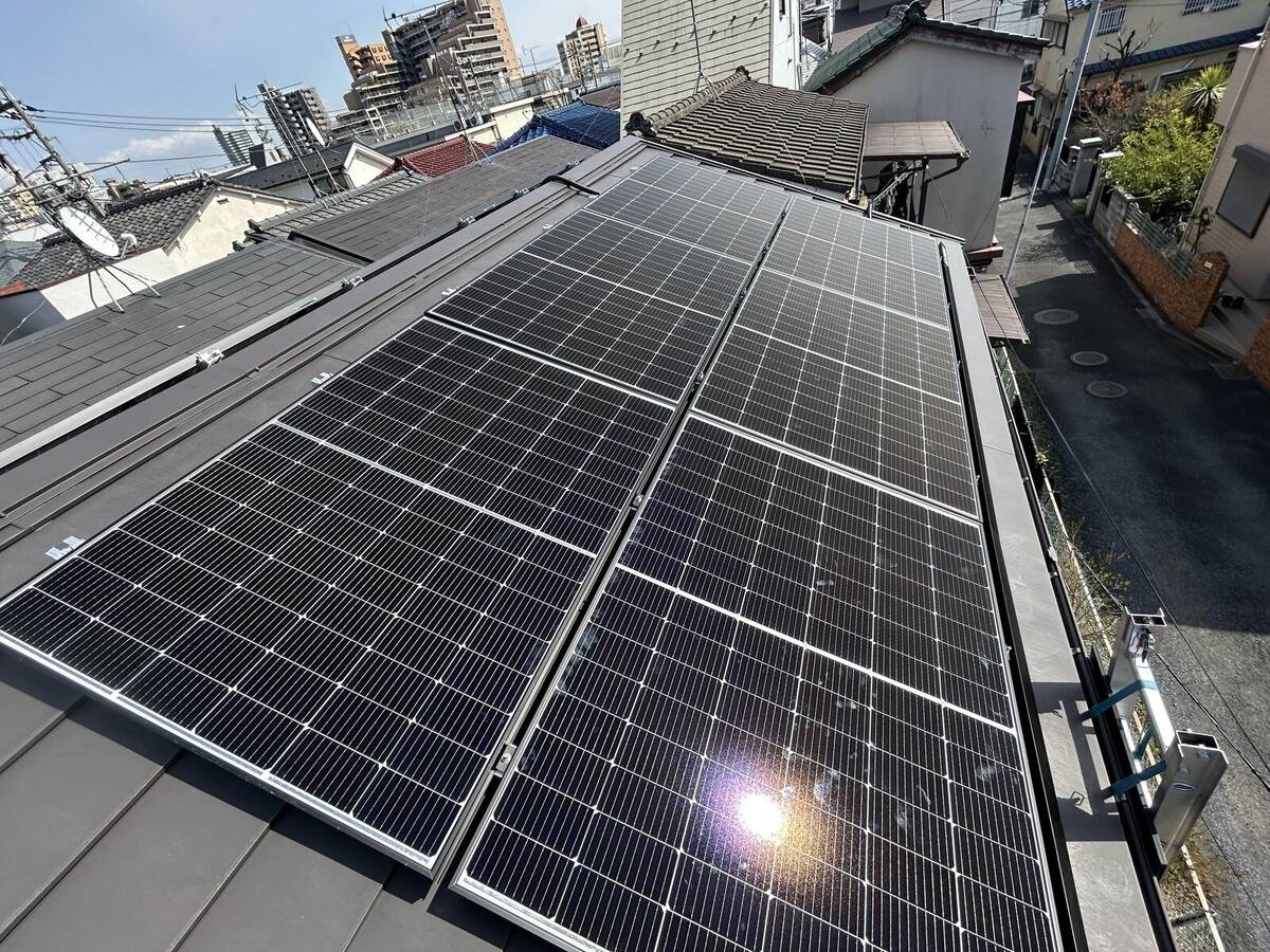 細長い屋根の大型太陽光アレイと白色蓄電池