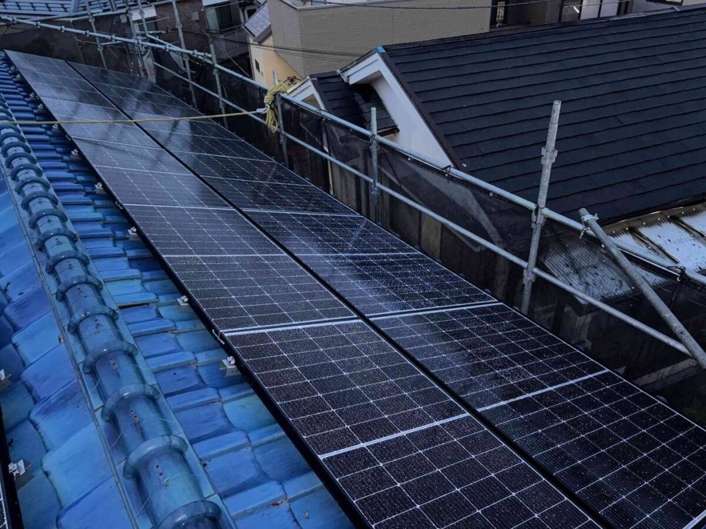 青い瓦屋根の太陽光パネルと二台構成の蓄電設備