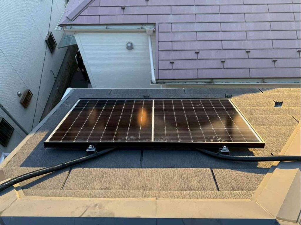 瓦屋根に六枚設置した太陽光パネルと屋外蓄電池